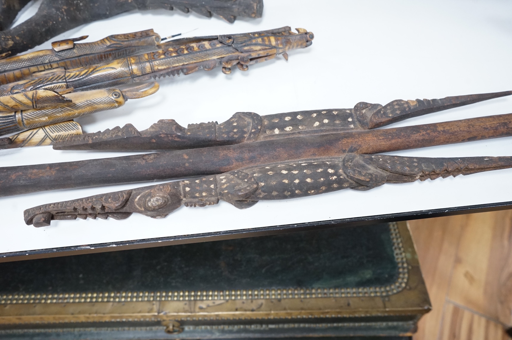 Two Papua New Guinea Sepik River carvings and a carved bone artefact, largest 92cm in length